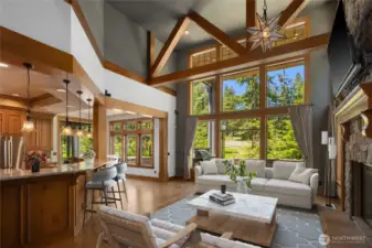 Breathtaking wall of windows frames serene forest views, flooding this vaulted great room with natural light—perfect for cozy gatherings and elegant entertaining.