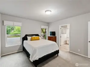 Large primary suite with large west facing windows and full sized walkin shower