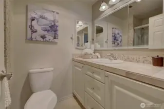 The primary bath has lovely tile work and great storage.