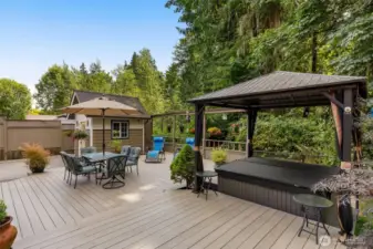 You will enjoy this massive deck with covered Jacuzzi surround by lush trees!