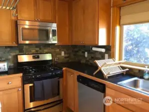 Sunny west facing kitchen with warm wood cabinets and stainless steel appliances.