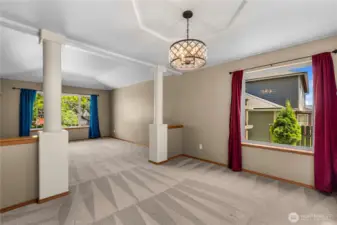 Open concept living and dining room with decorative tray ceilings.