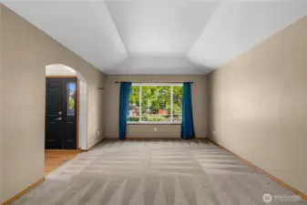 Open concept living and dining room with decorative tray ceilings.