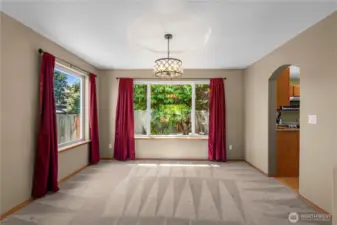 Open concept living and dining room with decorative tray ceilings.