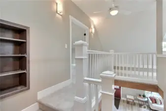 Upstairs features custom craftsman open railings, paddle fan for destratifying air distribution, cabinet curio & wall sconces.