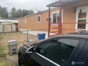 Fenced backyard beyond parking space.