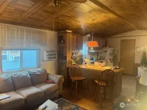 Livingroom with a/c unit & breakfast counter in backgrnd.