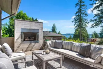Outdoor living room with lake views and a gas fireplace