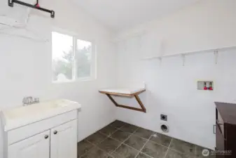 Laundry room with folding table and laundry sink.