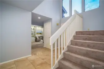 From the family room, circle back to the front entryway, where you'll once again be greeted by large picture windows and soaring ceilings. The staircase leads to the primary suite and three additional bedrooms.