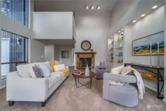 Looking back toward the entryway, you'll find a lovely brick wood-burning fireplace and a glimpse of the loft above, a unique feature of the primary suite on the upper floor.