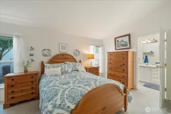 Primary bedroom and a view of entry to the primary bathroom with walk in shower, double sinks and commode area.