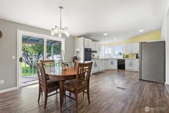 This photo showcases the open and inviting design, highlighting the functionality and aesthetic appeal of the combined eating and kitchen areas. The natural light, combined with the warm tones, creates a comfortable and welcoming atmosphere.
