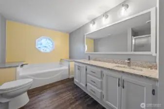 Large primary bathroom with a roomy double vanity, complete with fresh granite surfaces