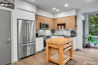 Open concept kitchen with stainless steel appliances and stone counters