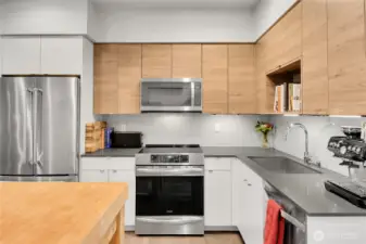 Open concept kitchen with stainless steel appliances and stone counters