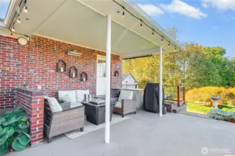Covered Patio with curtains, heater, and plenty of space for outdoor entertaining on chili evenings