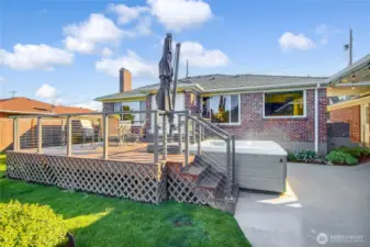 Hot tub tucked in beside deck in cedar fenced yard.