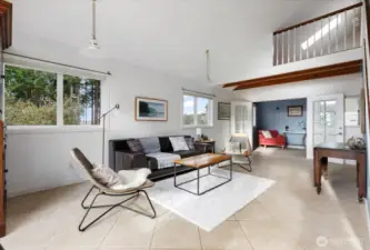 Living room showing french doors to office space beyond, loft above.
