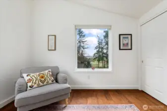 Primary bedroom has a beautiful view of the water, large closet, vaulted ceilings and a ceiling fan.