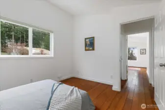 Second bedroom looking through to primary bedroom. Nook on the left of door would be a great space for future bathroom expansion.