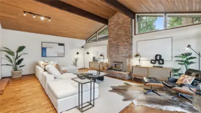 Mid-century modern charm with clean lines, white wall contrasting with timbered floor & ceiling in living room.