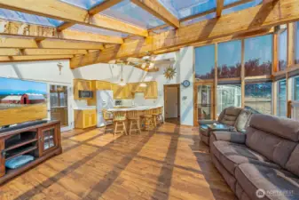 Large sunroom with kitchen and view of the attached green house