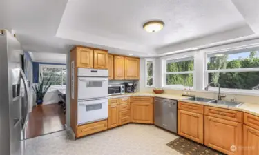 Spacious kitchen with double oven, cooktop, stainless appliances, and double sink.