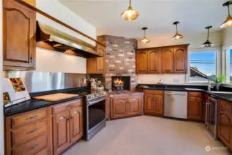 Large kitchen with big hood over the range & a fireplace.  Views from the corner sink.