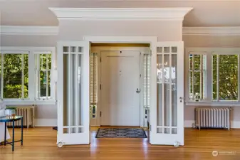 So many architectural details: large crown molding, French doors from the entry to the living room, sidelights flanking the entry door.