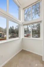 Step up and take in the view: four windows, all with blinds for privacy, let you soak in the surrounding trees and neighborhood vibe. There’s even space for a small chair or bench, making this landing the perfect nook for a quiet moment.