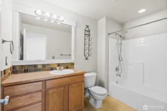 Custom tile in the upper-level full bath nicely serves bedrooms two and three.