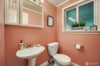 Powder room on main floor with privacy window, medicine cabinet & crown molding