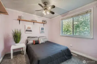 Bedroom #4 with carpet, on the back side/East of home offers shelving, ceiling fan, bifold closet doors with built-in clothes rack