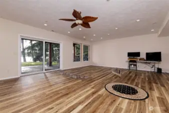 The downstairs rec room with beautiful brand-new flooring. Notice the hookups for a kitchen! You could make this downstairs a complete apartment of its own!