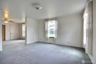 Large light-filled iving room with dining room to the left offering ease of entertaining.