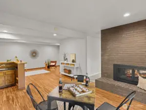 A wet bar is centralized in the space nearby, nicely separated by another gas fireplace.