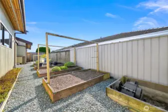 There are raised garden beds in a fenced in area   on the south side of the home