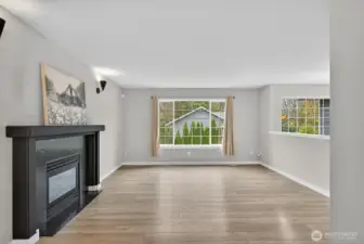 Inviting main-level living area with large windows, gas fireplace, and an open layout ideal for both relaxing and entertaining.