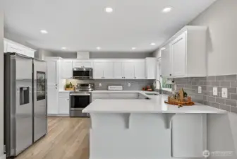 Modern kitchen designed for efficiency and style, offering expansive quartz counters and impressive cabinet storage throughout.