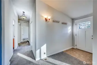 Down the hall from the entry leads to second full bath, den, guest room and primary bedroom.