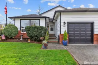 Charming, covered entry with brick accents, a welcoming front door, and tasteful seasonal décor. Pride of ownership shines throughout the exterior.