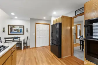Kitchen with stainless steel appliances, built-in double oven, and wood cabinetry. Dining nook offers room for seating.