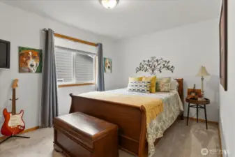 Bedroom featuring neutral carpeting, and window with privacy coverings.