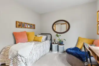 Alternate view of the bedroom showing decorative shelving, seating area, and closet access. Neutral palette and soft lighting enhance the space.