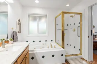 Bathroom with separate jetted tub and enclosed shower. Gold-tone fixtures and tiled surfaces provide a clean, functional layout.