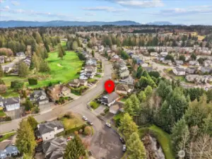 Aerial perspective highlighting tree-lined streets, nearby amenities, and the home’s position within the community.