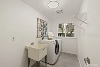 Extra large laundry room next to the garage, including a wash basin and storage space.