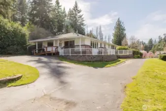 Blacktop driveway with open parking and a wheelchair ramp near the sliding glass door.
