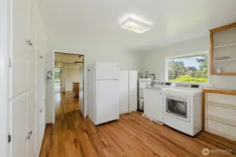 Utility room with hardwood floors and built-in cabinets.